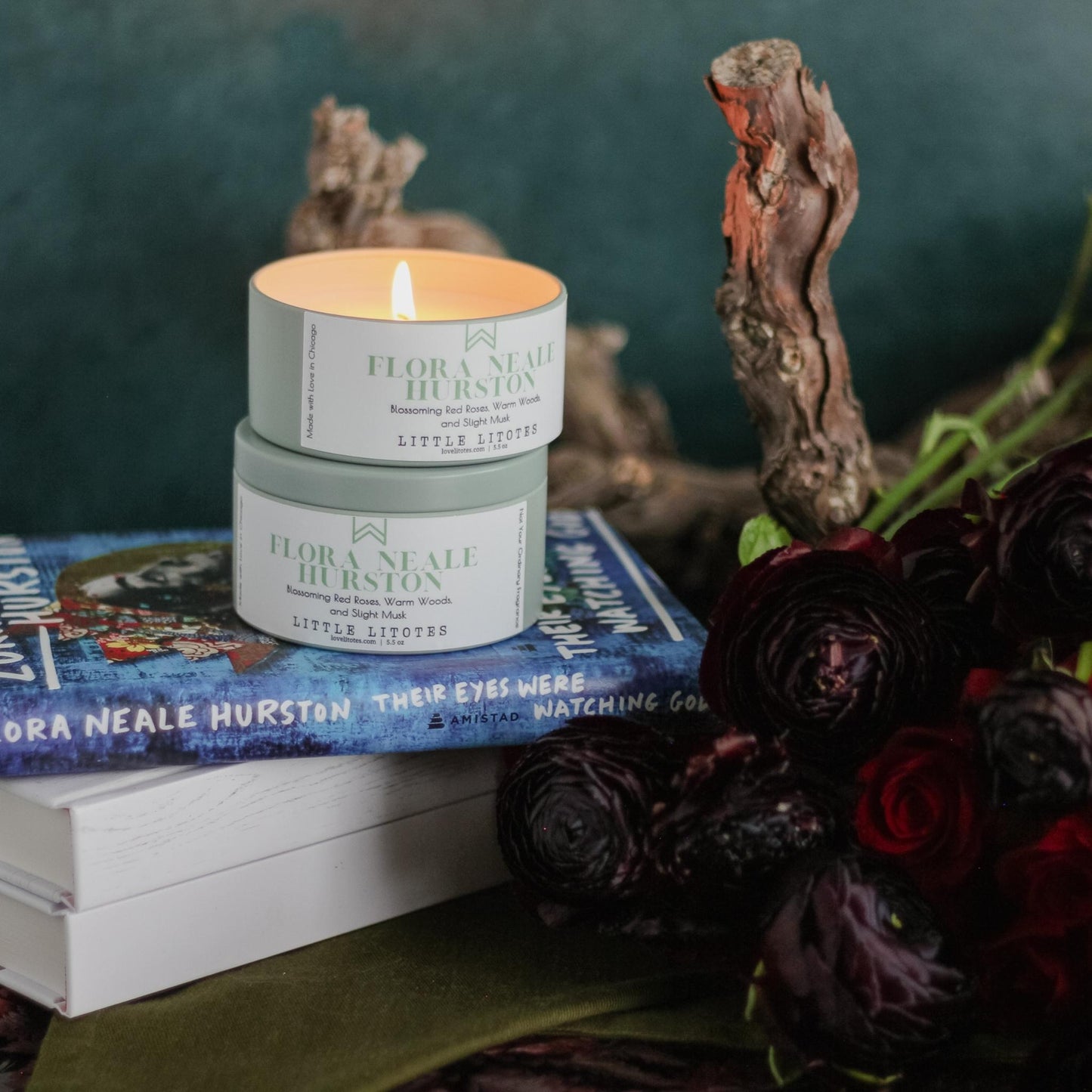 Travel-ready candle by Black-owned, woman-owned, Chicago-based Litotes. The candle sits on Their Eyes Were Watching God by Zora Neale Hurston. The candle has the lovely aroma of roses, woods, and slight musk. Flora Neale Hurston, celebrating author Zora Neale Hurston.